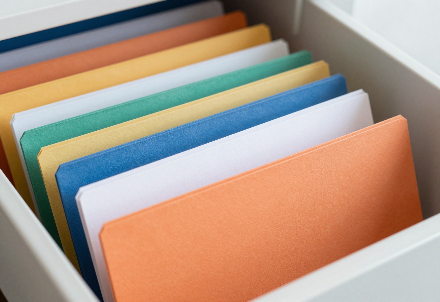 Colorful file folders with blank tabs in a drawer