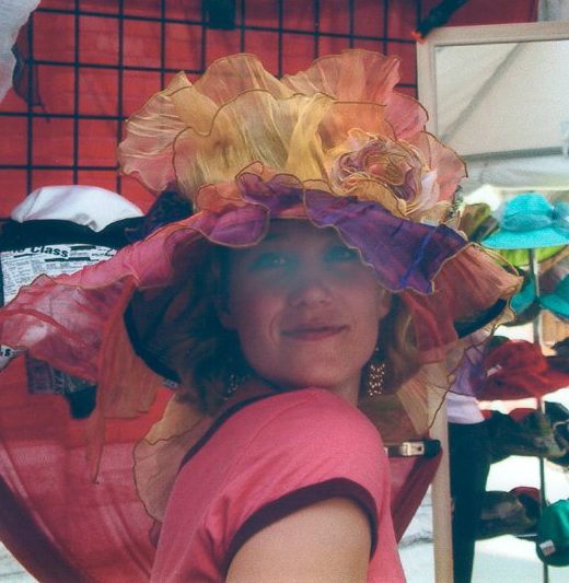 Karen Blodgett, Michael's late wife and business partner, wearing a large colorful hat and smiling