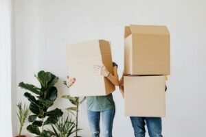 Couple holding cardboard boxes and preparing for relocation