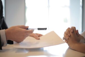 Businessman giving a contract to a woman for her to sign it